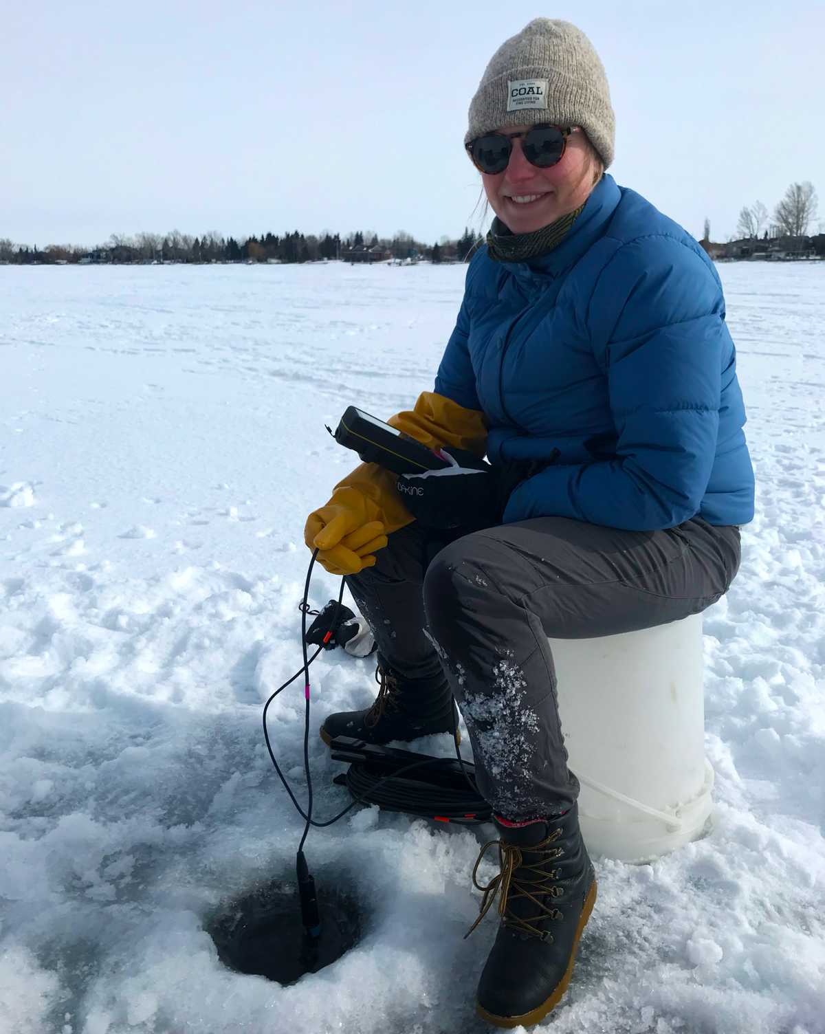 DataStream’s Mary Kruk learning how Winter LakeKeeper volunteers collect water quality data, using a probe to measure temperature and dissolved oxygen, and collecting bottled water samples for lab analysis.